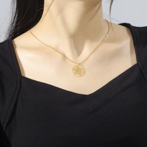 Gros plan d'un collier géométrique doré avec pendentif Cube de Métatron sur un mannequin
