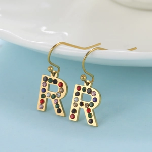 Gros plan de boucles d'oreilles crochet dorées avec lettre R et strass colorés vibrants