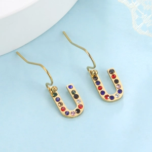 Détail de boucles d'oreilles en U dorées avec des strass multicolores en gros plan de haute qualité