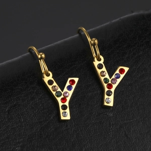 Gros plan sur des boucles d'oreilles lettre Y dorées avec strass colorés sur cuir