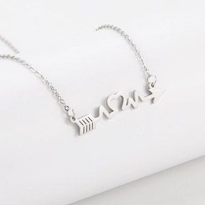 Close-up of stainless steel necklace with heartbeat and arrow pendant on white background