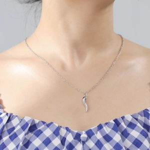 Polished silver cylindrical pendant necklace on model with blue checkered shirt