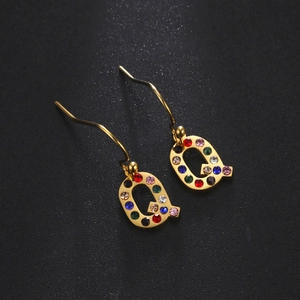Boucles d'oreilles lettre Q dorées style hip hop avec strass colorés sur fond noir