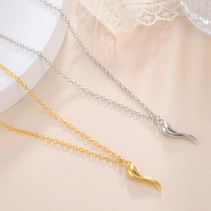 Detail of gold and silver Italian Corno horn pendants on delicate rolo chains