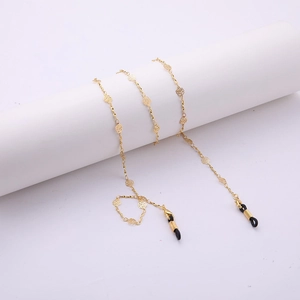 Détail d'une chaîne de lunettes dorée avec motifs roses ajourées et boucles noires
