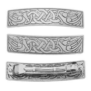 Detailed macro view of vintage metal hair clip with Celtic knots and embossed bird motif