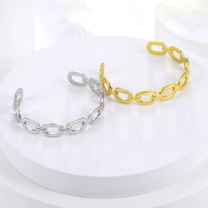 Detail of gold and silver plated hollow chain bangle bracelets on minimalist white pedestal