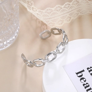 Silver geometric stainless steel chain cuff bracelet on minimalist display stand