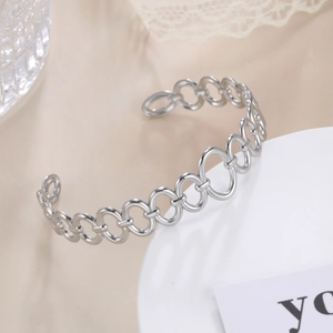 Detail of adjustable silver chain-link cuff bracelet with a polished metallic finish