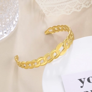Detailed view of the gold hollow chain link bracelet on a white ceramic stand