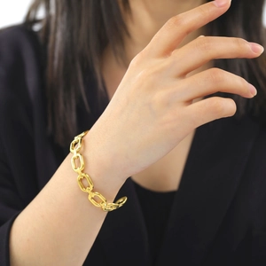 Polished gold geometric thick link chain bracelet in stainless steel on female model