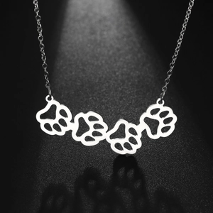 Minimalist silver stainless steel necklace with four hollow dog paw print pendants