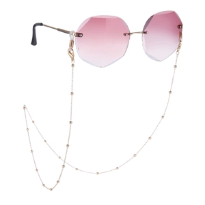 Detail van achthoekige randloze zonnebril met roze verloopglazen en gouden ketting