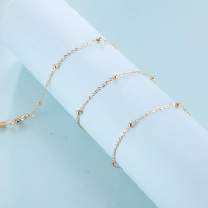 Detail van de 18K vergulde brillenketting met ronde kralen en siliconen lussen