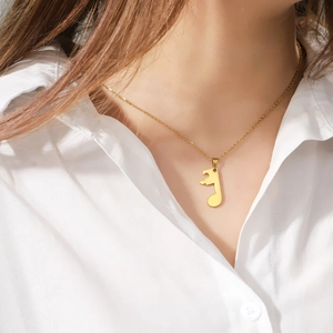 Detailed view of a gold musical note puzzle pendant necklace on a delicate chain