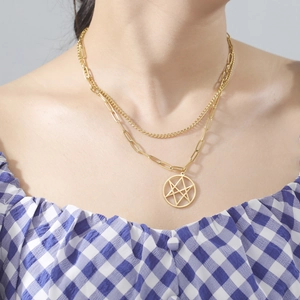 Détail d'un collier doré à double rangée avec pendentif étoile dans un cercle