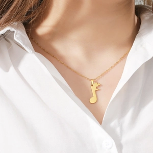 Golden musical note pendant necklace for women worn on neck with white shirt