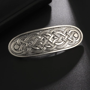 Detail of silver Celtic knot hair clip featuring intricate metal textures and patterns