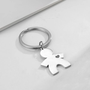 Macro view of a silver stainless steel person-shaped keychain with heart cutout detail