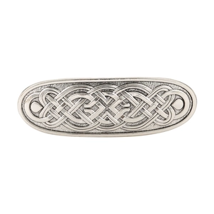 Vintage silver Celtic knot hair clip with retro embossed metal texture on white backdrop