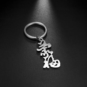 Macro shot of silver stainless steel keychain featuring a hollowed calligraphy pendant