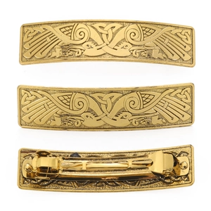 Detail of vintage gold metal hair clip with intricate Celtic crane bird engraving