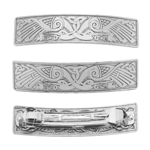 Detail of three vintage silver hair clips featuring intricate crane patterns and metal spring clips