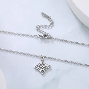 Détail du collier en acier inoxydable argenté avec pendentif trèfle ajouré à nœud celtique