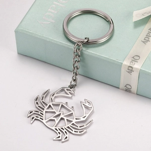 Minimalist hollow crab stainless steel keychain with a polished silver finish on green gift box