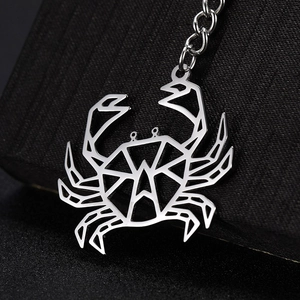 Macro shot of silver stainless steel keychain with hollow geometric crab design