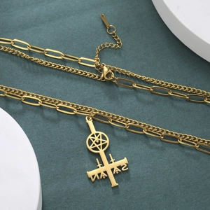 Close-up of golden layered necklace with inverted cross and pentagram star pendant