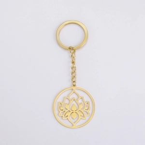 Macro detail of golden hollow lotus pendant and key ring in polished stainless steel