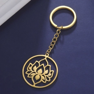 Detailed view of a golden hollow lotus pendant keychain on a dark blue texture background