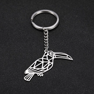 Macro detail of silver geometric cutout toucan pendant on polished stainless steel keychain