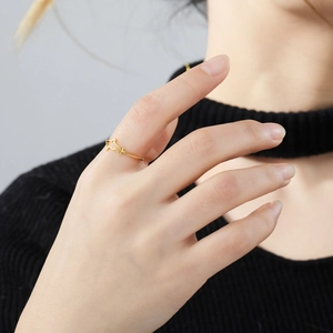 Anillo minimalista de acero dorado con diseño de tiburón hueco puesto en el dedo