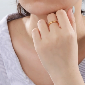 Minimalist polished golden stainless steel ring band shown on a hand in natural light