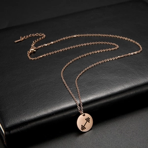 Detail of rose gold dumbbell pendant on leather surface for fitness lovers