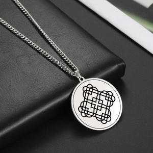 Dettaglio della collana in acciaio argento con amuleto geometrico su pelle nera