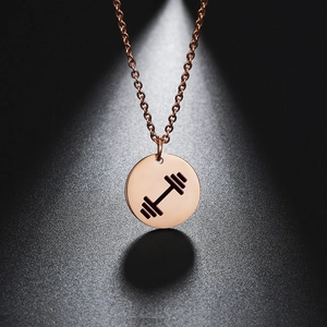 Macro shot of rose gold barbell round pendant necklace with artistic lighting shadow