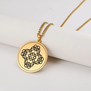 Dettaglio di una collana talismano in titanio dorato con ciondolo tondo geometrico