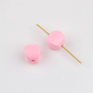 Close-up of pink acrylic cube beads with vertical holes for DIY jewelry making
