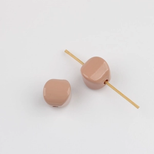 Detailed view of glossy nude pink acrylic beads with vertical holes for DIY jewelry