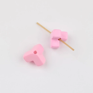 Detailed view of pink triangular acrylic beads with threading holes for DIY jewelry