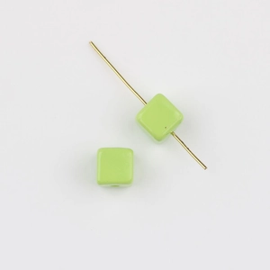 Detail of light green acrylic cube bead on golden pin for DIY jewelry making and crafts
