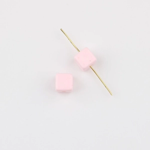 Macro detail of pink acrylic cube beads with straight holes for DIY jewelry crafting