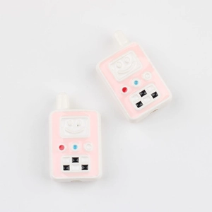 Close-up of pink acrylic walkie-talkie shaped beads with cute smiley face for DIY jewelry