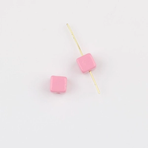 Detailed macro view of two pink square acrylic beads with glossy finish for DIY jewelry