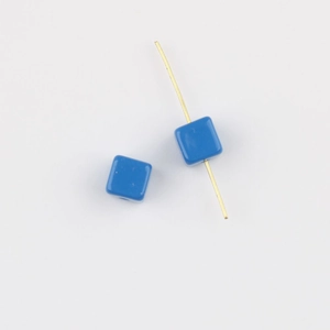 Detail view of glossy blue acrylic cube beads with hole for DIY jewelry making
