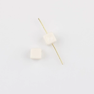 Macro detail of creamy white square acrylic beads with center hole for DIY jewelry making