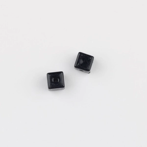 Macro detail of black acrylic square cube beads with center holes for DIY jewelry making